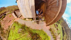 A circular wooden structure with a central open area, surrounded by a grassy landscape. - San Vicente (San Vicente)