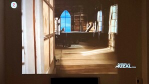 A projection of a room with a large window, a staircase, and a flat-screen TV mounted on the wall. - Cozy Modern Place with Projector @ Near Pink Church (Thành phố Hồ Chí Minh)