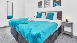 Un dormitorio moderno con una cama grande, una mesita de noche, un armario y un espejo.