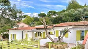 A white building with green shutters and a red-tiled roof. - Les Bouganvilles by SolturElba (Capoliveri)