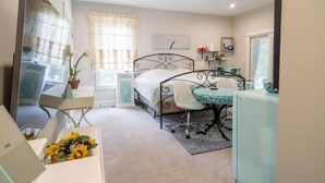 Une chambre à coucher comprenant un lit, une table de chevet, une chaise, un bureau et une petite table avec une chaise.