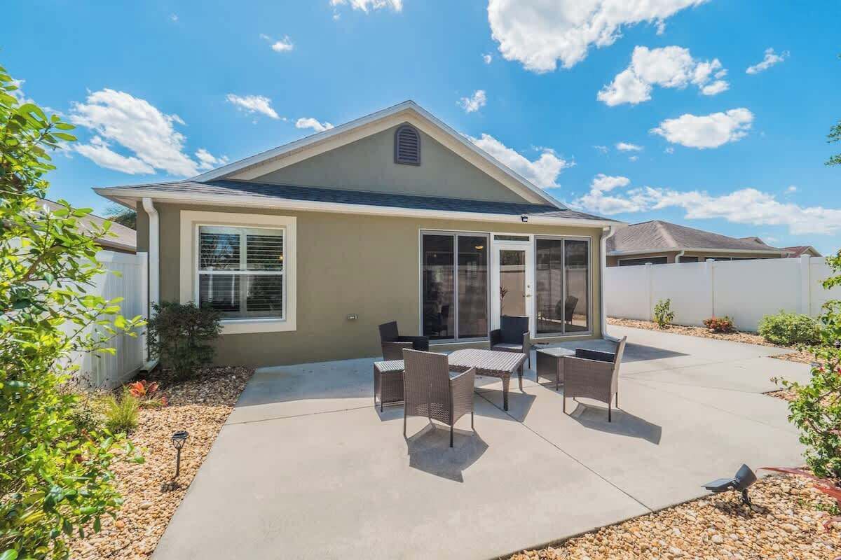 Ein Bungalow mit überdachter Terrasse, komplett mit Tisch und Stühlen.
