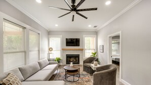 A modern living room with a sofa, armchairs, a coffee table, and a fireplace. - Pottboro Vacation Rental w/ Private Hot Tub! (Pottsboro)