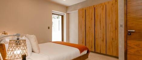 A modern bedroom with a wooden bed, white bedding, a wooden wardrobe, and a nightstand with a lamp.