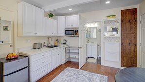 A modern kitchen with white cabinetry, a built-in microwave, and a refrigerator. - Remodeled Studio w/Fast Wi-Fi in Heart of Bay Area (Milpitas)