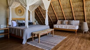 Une chambre à coucher avec un lit à baldaquin, un canapé, un banc et un panier en osier.