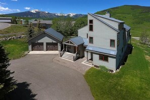 A two-story building with a garage, a covered porch, and a driveway.
