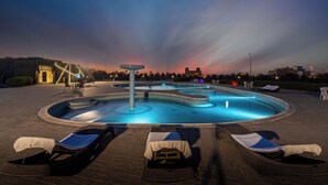Una piscina con sillas de descanso y una fuente.