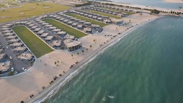Stunning coastal hotel area with uniform buildings, lush lawns, and beach access.