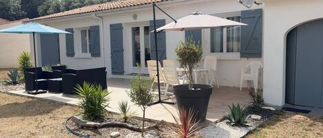 Un patio con mobiliario exterior, una planta en maceta y una antena parabólica.