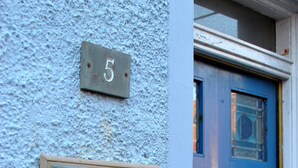 A blue door with a small window and a metal number plate above it. Below the door, there is a sign that reads "SEA HOLLY COTTAGE". - Sea Holly Cottage- coastal retreat Pittenweem (Pittenweem)