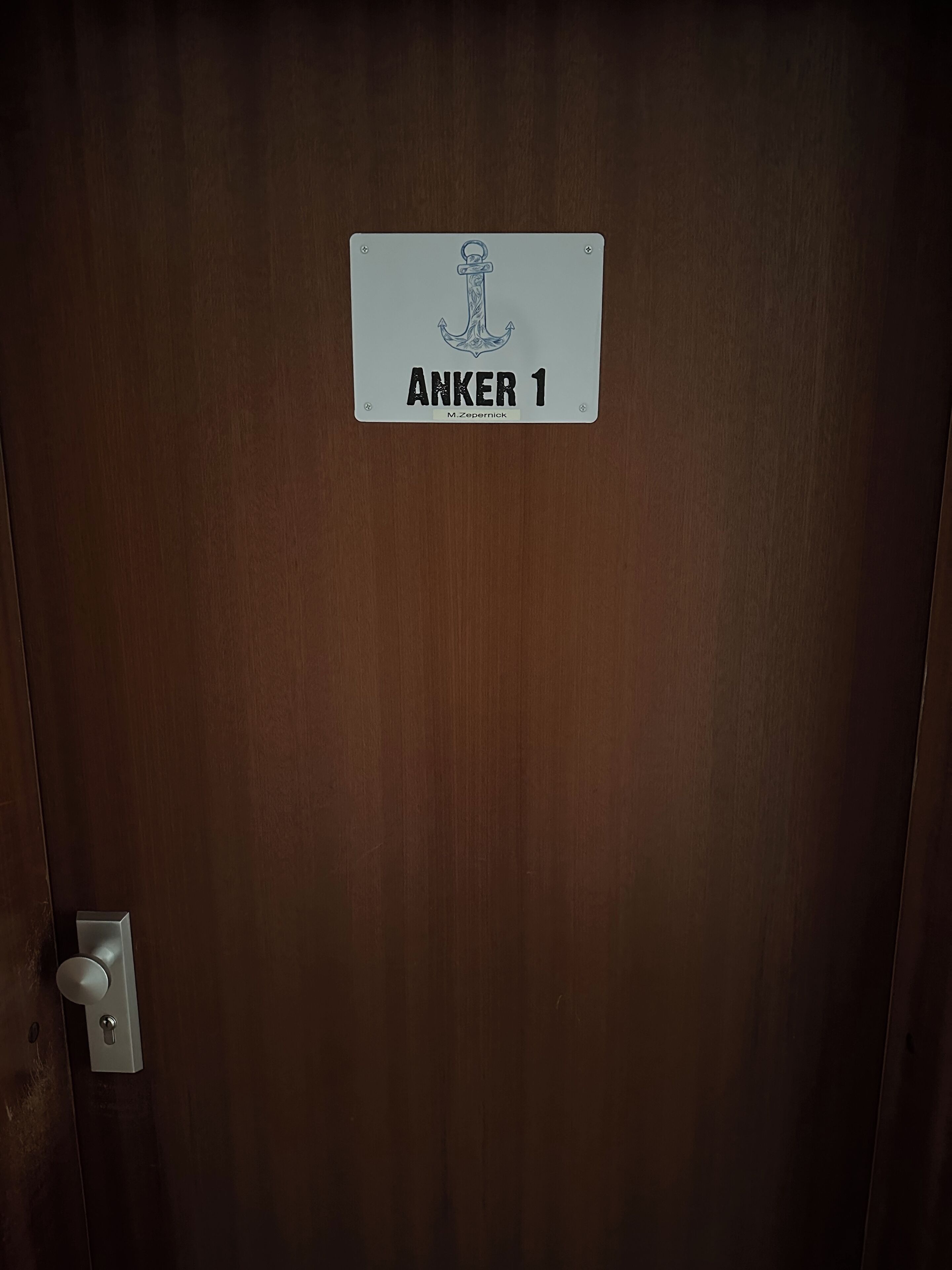 Una puerta con un letrero que dice "ANKER 1" y una cerradura.