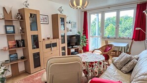 A cozy room with a sofa, a dining table, a TV, and a bookshelf. - Karsten by Interhome (Zinnowitz)