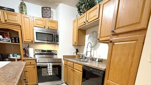 A kitchen with wooden cabinets, a microwave, an oven, a dishwasher, and a granite countertop. - Spacious 5 Bedroom Home, two blocks to FSU. Oversized parking for up to 8 cars (Tallahassee)