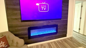 A flat-screen TV mounted on a wall with a wooden panel design. - Spacious 5 Bedroom Home, two blocks to FSU. Oversized parking for up to 8 cars (Tallahassee)