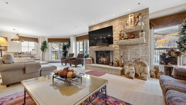 A spacious living room with a fireplace, comfortable seating, and a large TV. - Beaver Creek Centennial 2 Bedroom #17 (Avon)