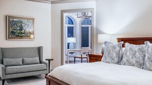 A bedroom with a bed, a grey sofa, a desk, and a window. - Beaver Creek Village Ski In, Ski Out 3 Bedroom (Avon)
