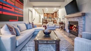 A modern living room with a sectional sofa, a coffee table, and a fireplace. - Beaver Creek Village Ski In, Ski Out 3 Bedroom (Avon)
