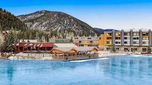 A hotel with a pool, wooden deck, and mountain backdrop. - Lakeside Village 1 Bedroom Condo in Lakeshore Complex (Keystone)