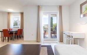 Relax in a spacious room with a large bed, separate desk area, and dining space, plus a balcony with a view.