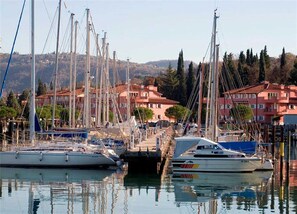 Boats docked in a picturesque marina surrounded by buildings with red-tiled roofs.