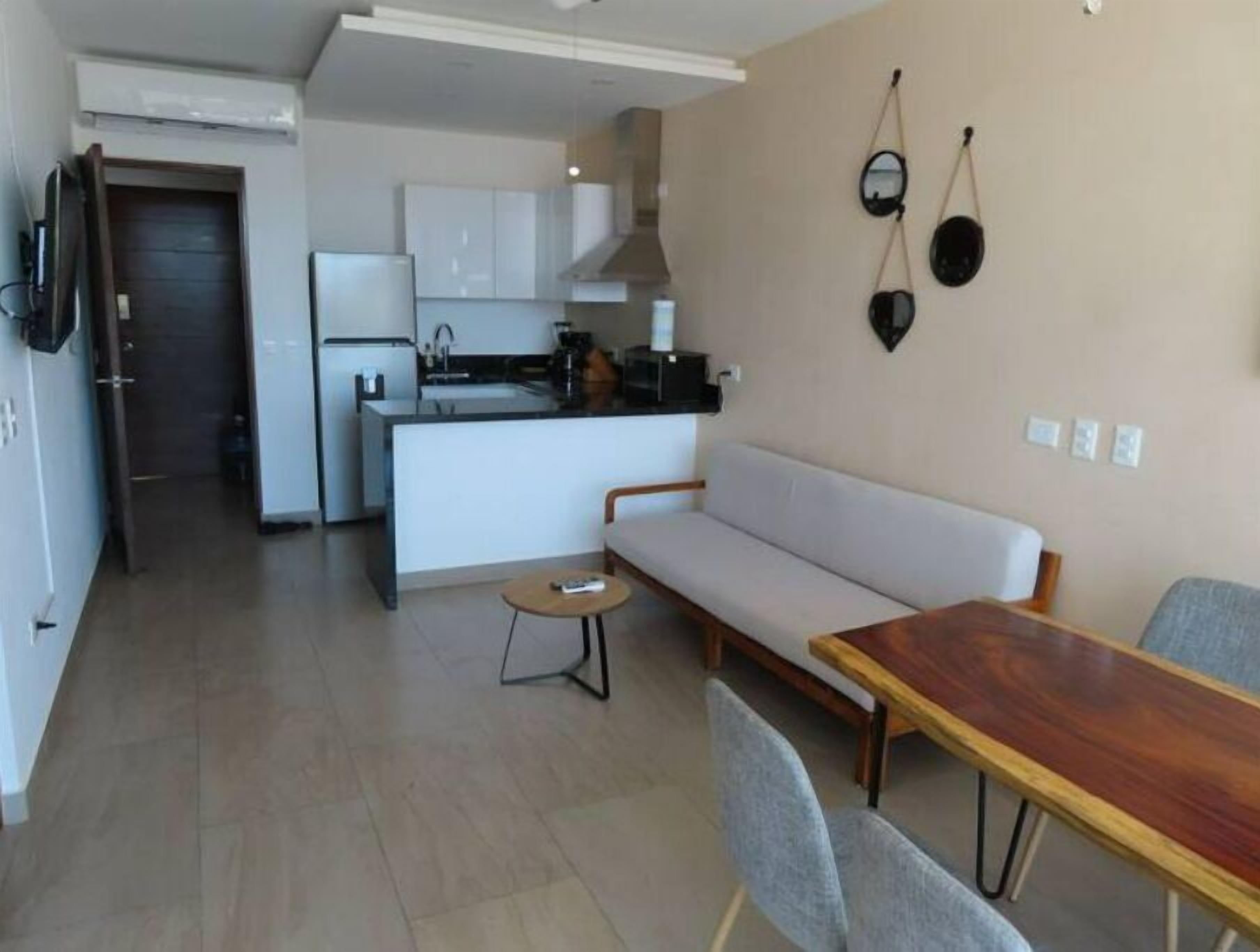 Um apartamento moderno com cozinha, sala de jantar e sala de estar.