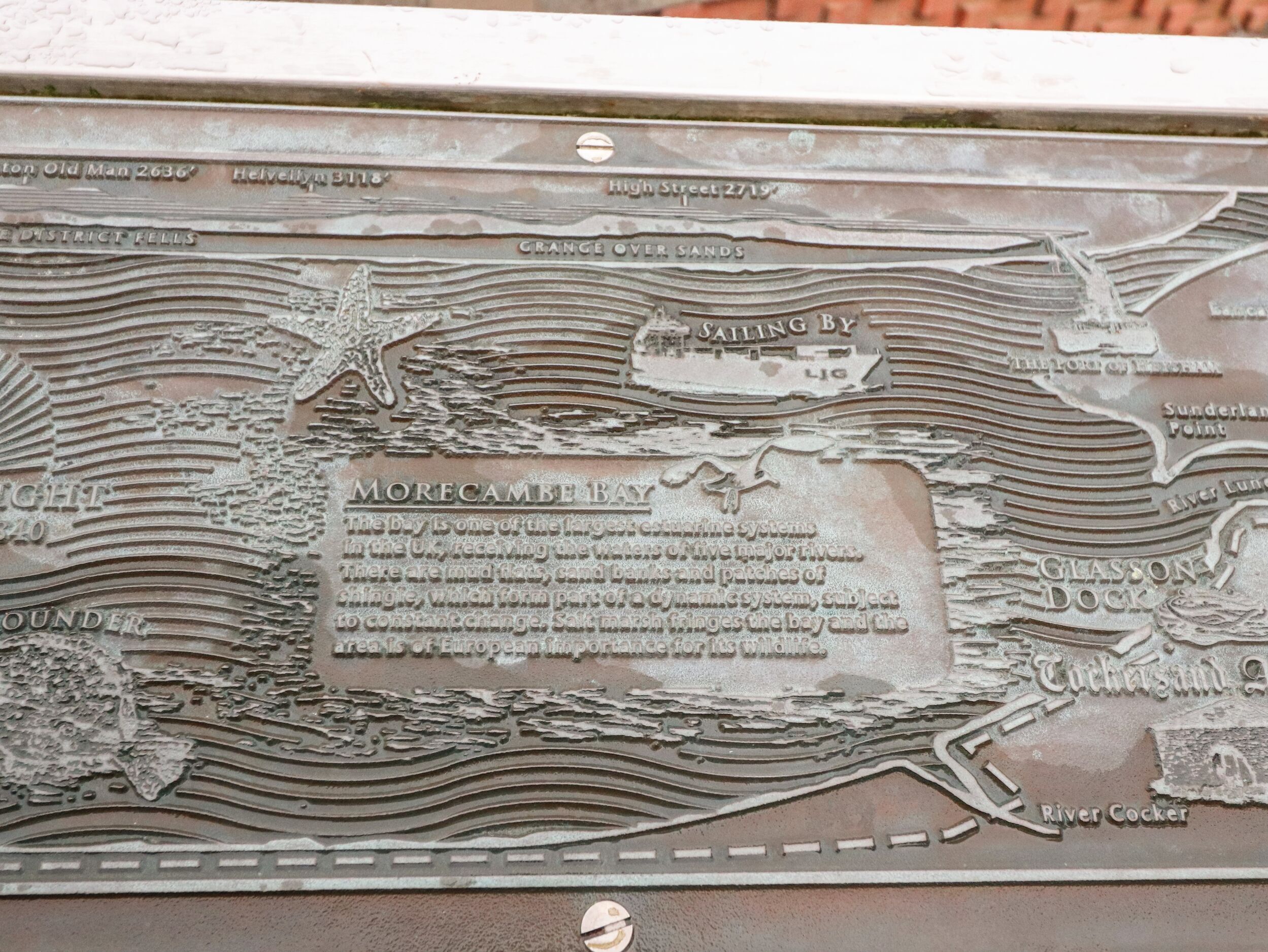 A detailed metal plaque with engraved text and a map, likely a historical marker or informational plaque.