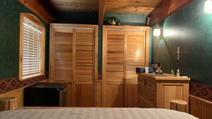 A bedroom with wooden wardrobes, a bed, a small desk, and a nightstand. - Mountain Cabin: 2 bed/2 bath, Fire pit, Close to Yellowstone and a moose family! (Island Park)