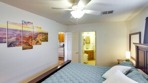 A bedroom with a bed, a ceiling fan, and a wall with four paintings. - Dog-Friendly Bullhead City Home - Walk to River! (Bullhead City)