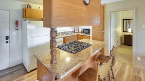 A kitchen with wooden cabinets, a built-in stove, and a microwave. - Dog-Friendly Bullhead City Home - Walk to River! (Bullhead City)