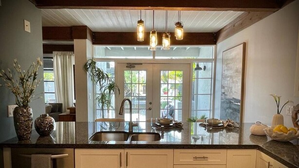 A kitchen with a large island, a double sink, and pendant lighting. - 04 Rustic meets beachy in Wilton Manors! (Wilton Manors)