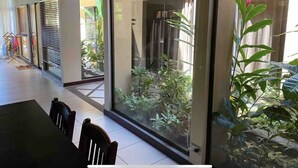 Ein modernes Interieur mit Essbereich, großen Fenstern und Blick auf einen Garten.