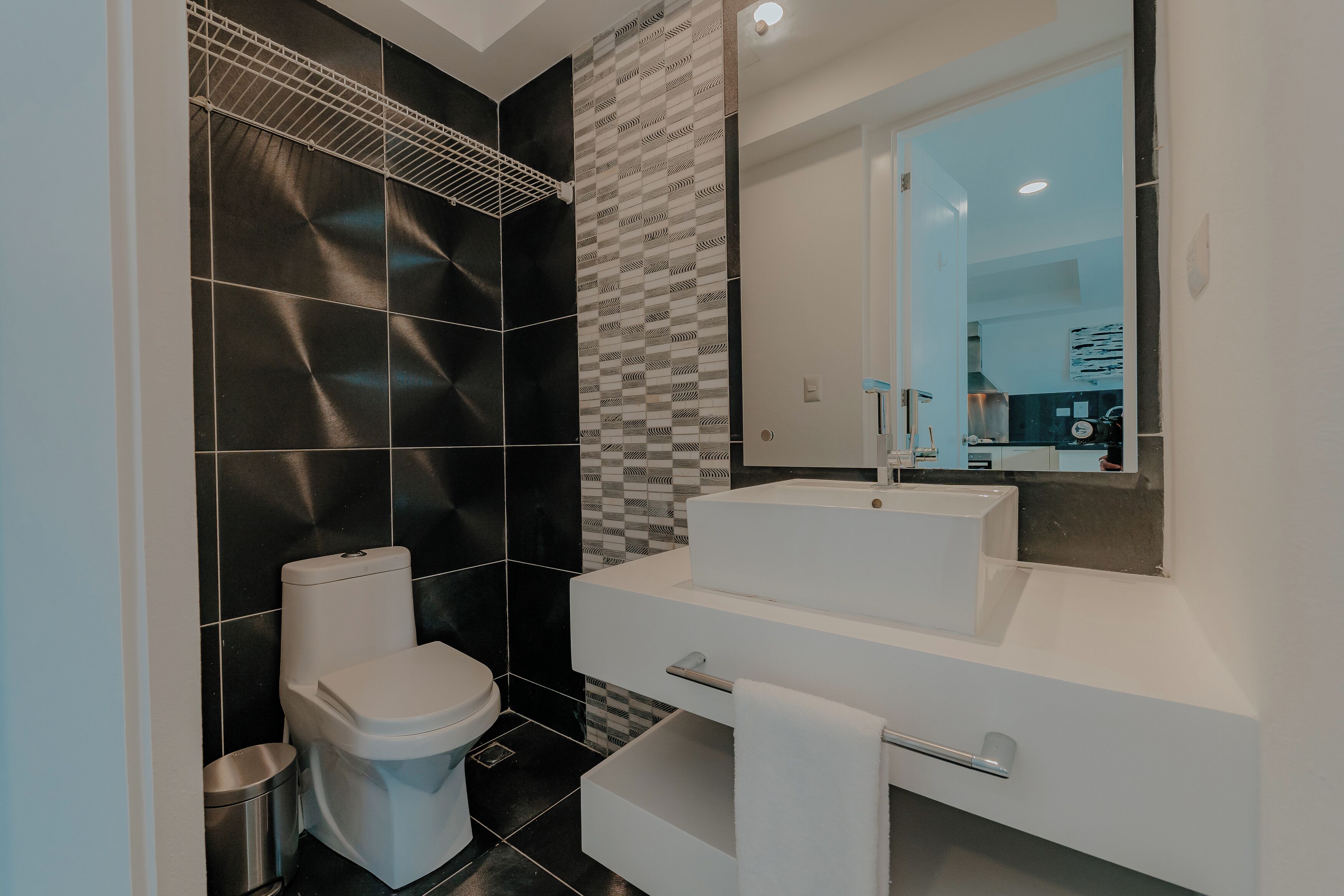 A modern bathroom with a toilet, a sink, and a mirror.