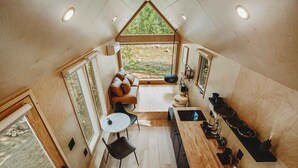 A compact kitchen with a dining area, a small table, and a sofa.