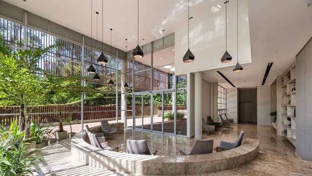 A spacious lobby with a curved seating area, large windows, and hanging pendant lights. - Stunning views from 25th-floor condo! El Poblado! (Medellín)