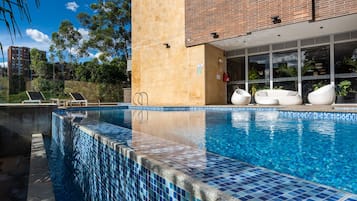 Una piscina al aire libre, una piscina climatizada