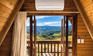 A wooden balcony with a view of a mountainous landscape.