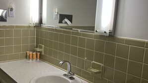 Une salle de bain avec un lavabo blanc, un miroir et un porte-serviettes.