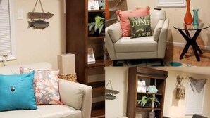 Ein Wohnzimmer mit einer Couch, einem Couchtisch mit dekorativen Gläsern, einem Holzschrank und einem Essbereich mit Tisch und Stühlen.