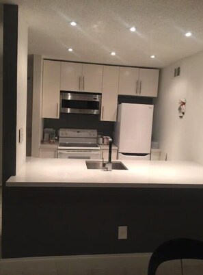 Enjoy cooking in this well-equipped kitchen with a central island, sink, and stainless steel oven.