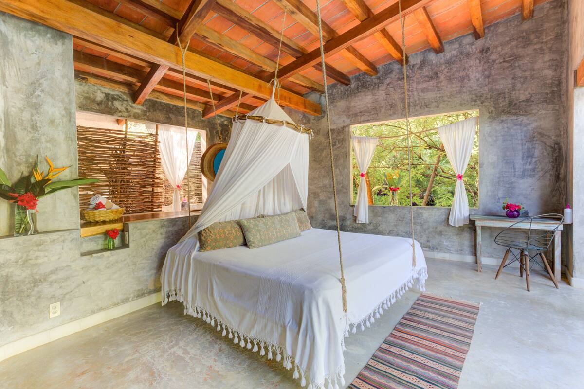 Un dormitorio con cama, escritorio y una silla.