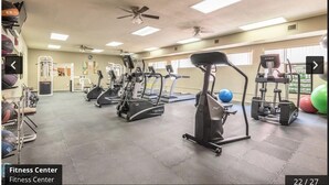 Un gimnasio con cintas de correr, elípticas y pesas libres.