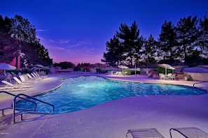 A swimming pool with lounge chairs and umbrellas, surrounded by trees and a clear sky. - CASA MONTANA - Anasazi Village - 2nd Floor View (Phoenix)