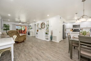 A modern kitchen with white cabinets, a microwave, and a refrigerator.