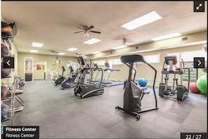 A gym with treadmills, elliptical machines, and free weights.