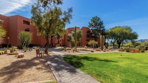A courtyard with a paved walkway, cacti, and trees. - CASA ANA - Anasazi Village - Updated unit, pool view. (Phoenix)