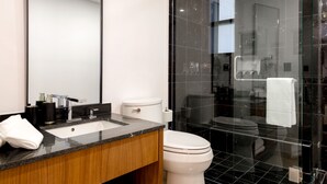 Ein modernes Badezimmer mit einer Duschkabine, einer weißen Toilette und einem schwarzen Waschtisch.