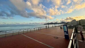 A coastal promenade with a red brick walkway, metal railings, and a clear view of the sea. - Las Canteras View Home (Las Palmas de Gran Canaria)