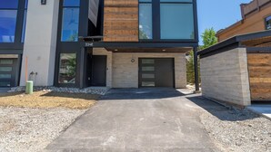 A modern two-story building with a combination of wood and glass facade, numbered 224E, featuring a driveway and a gravel area. - 224 Frisco Alley Unit E By Summit County Mountain Retreats (Frisco)