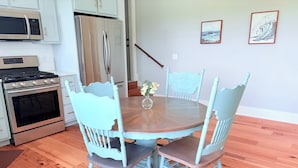 A dining area with a wooden table and four chairs, a refrigerator, a microwave, and a stove. - Spacious loft style apartment with gorgeous view (Watertown)